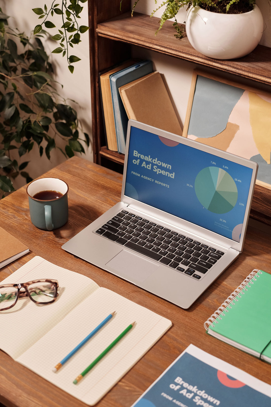 A bright, minimalist desktop workspace with a laptop, notebook, and coffee cup, illustrating a local business digital marketing strategy.